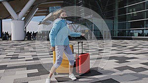 Teen girl with colorful suits dancing at the airport