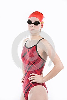 Teen girl in competition swim suit, swim cap and goggles.