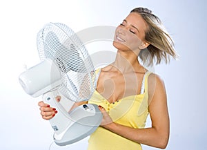 Teen girl cooling herself with fan