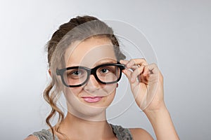 Teen girl corrects glasses