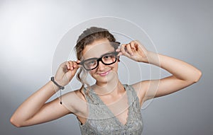 Teen girl corrects glasses