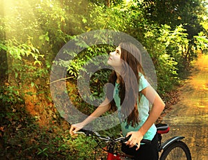 Teen girl cycling through vietnam jungle hill