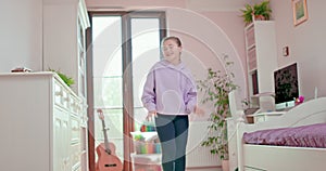 Teen girl is dancing and singing in her bedroom