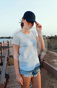 Teen girl in dark blue baseball cap and t-shirt