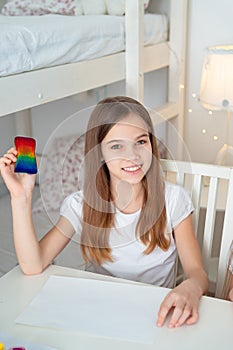 Teen girl drawing rainbow sponge. stay at home. photo