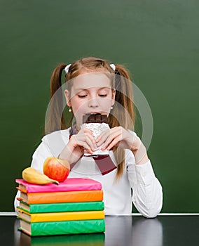 Teen girl eating chocolate at lunchtime