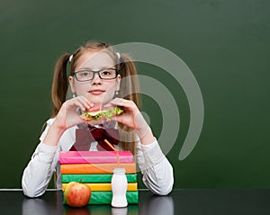 Teen girl eating a sandwich at lunchtime photo