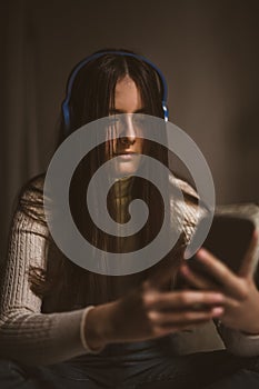 Teen girl excessively sitting at the phone at home.