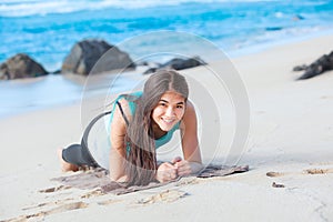 Teen girl exercising on sandy beach of Hawaii near ocean