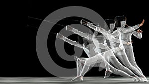 Teen girl in fencing costume with sword in hand isolated on black background photo