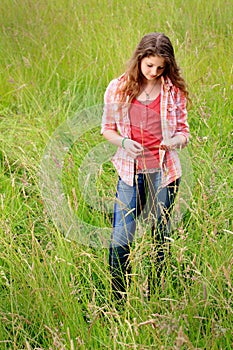 Teen Girl in Field Standing Thinking