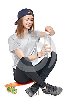 Teen girl in full length sitting on skate board