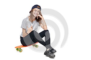 Teen girl in full length sitting on skate board