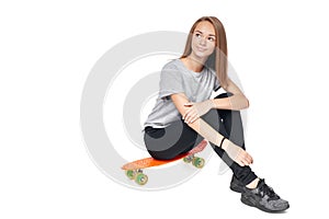 Teen girl in full length sitting on skate board