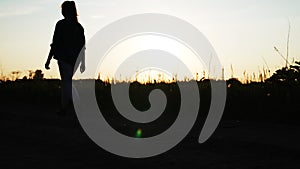 Teen girl goes across frame on the dirt rural road pan