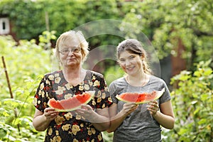 Teen girl and grandma with cut water melon slice close up photo