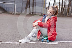 Teen girl with green skateboard in sport park