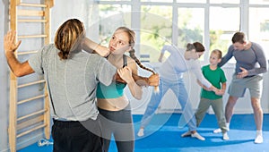 Teen girl in gym perform basic elements of krav maga self-defense system.