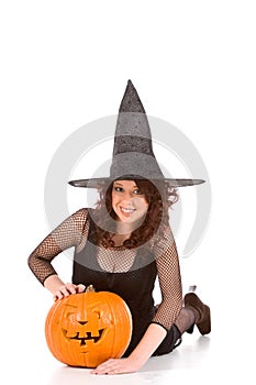 Teen girl in Halloween hat with carved pumpkin