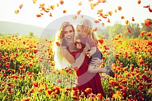 Teen girl and happy little boy child with flower red poppy, summer vacation, family, mothers day, childhood.