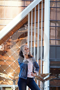 Teen girl having a mobile phone talk in a large metropolis