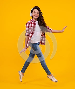 Teen girl in headphones listen to music. Wireless headset device accessory. Child enjoys the music in earphones on