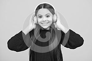 Teen girl in headphones listen to music. Wireless headset device accessory. Child enjoys the music in earphones on