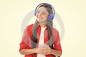 Teen girl in headphones listen to music. Wireless headset device accessory. Child enjoys the music in earphones on white