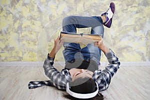 Teen girl in headset reading a book