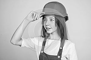 teen girl in helmet and boilersuit. child wear hard hat. kid builder on construction site. worker engineer. architect in
