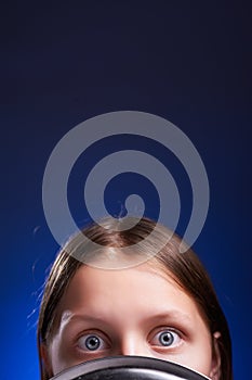 Teen girl hiding her face behind colander