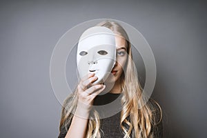 Teen girl hiding face behind mask