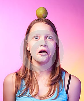 Teen girl holding an apple on her head as a target