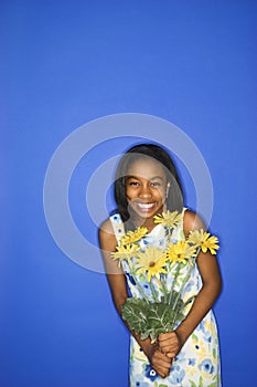 Teen girl holding flowers.