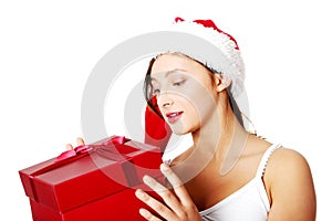 Teen girl holding and looking at gift.