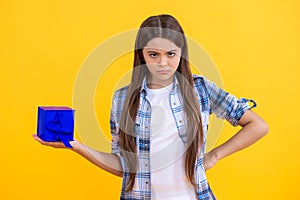 teen girl holding a present wrapped. serious teen girl show present on occasion. teen girl with present. teen girl