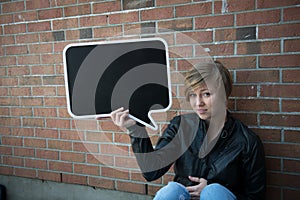 Teen girl holds black sign