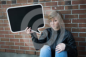 Teen girl holds black sign