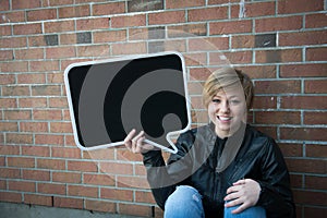 Teen girl holds black sign