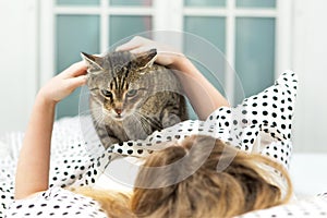 Teen girl hug cat in bed,