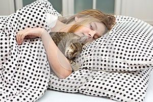 Teen girl hug cat in bed,