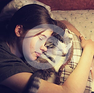 Teen girl hug cuddle cat in bed