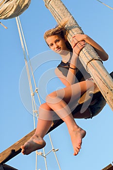 Teen girl hugging the mast