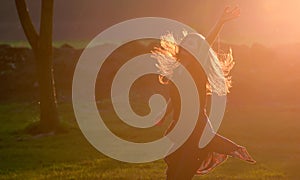 Teen girl jump against sunset in forest