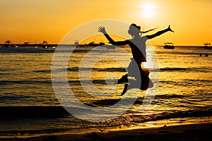 Teen girl jumping on the beach at the day time