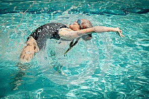 Teen girl jumping in the swimming pool
