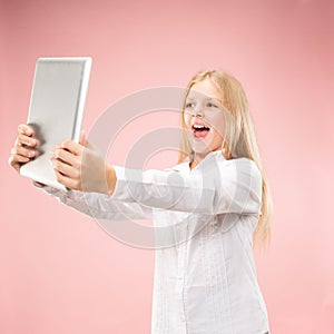 Teen girl with laptop. Love to computer concept. Attractive female half-length front portrait, trendy pink studio