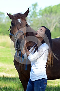 A teen girl laughs with her horse