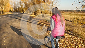 Teen girl learns to ride bike in park. hands of girl hold the bent handlebar.