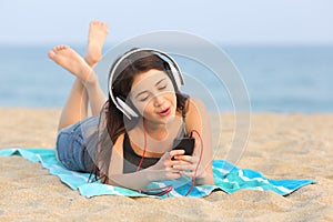 Teen girl listening music and singing on the beach